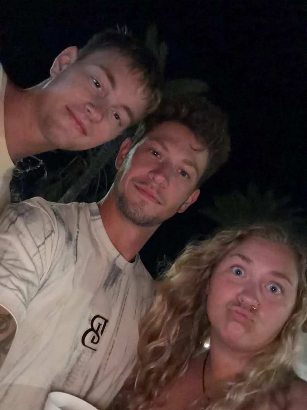 Kadin with two friends in a night-time beach selfie