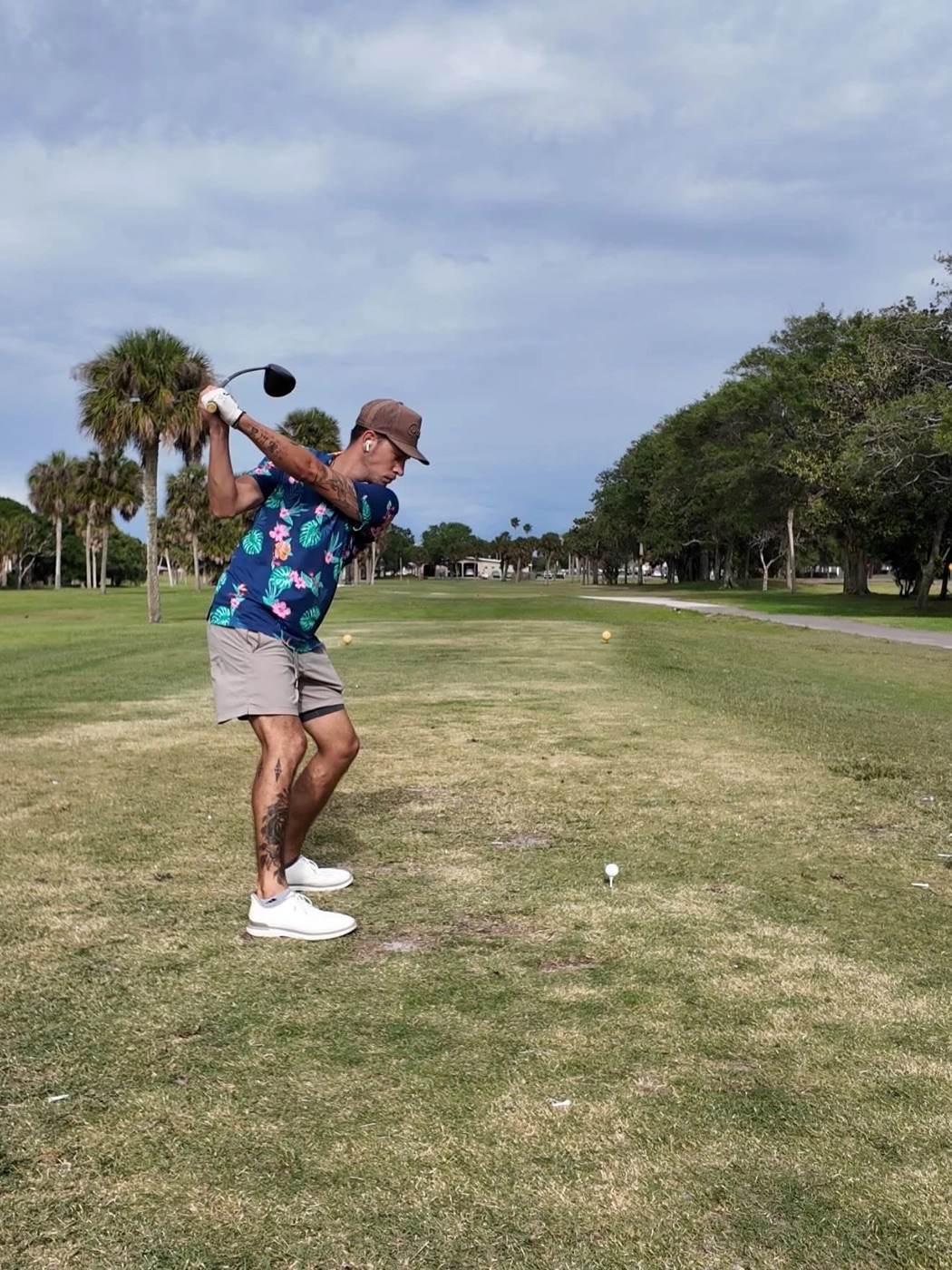 Kadin at the top of his backswing with a driver, mid-drive on a palm-lined Florida course